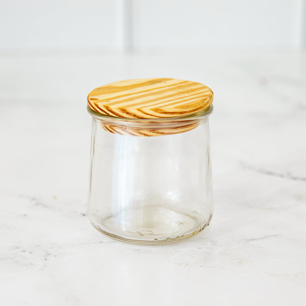 Oui by Yoplait glass yogurt jar with a wooden lid.
