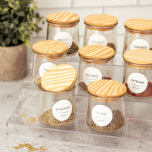 Oui by Yoplait glass yogurt jars with wooden lids used to store spices.
